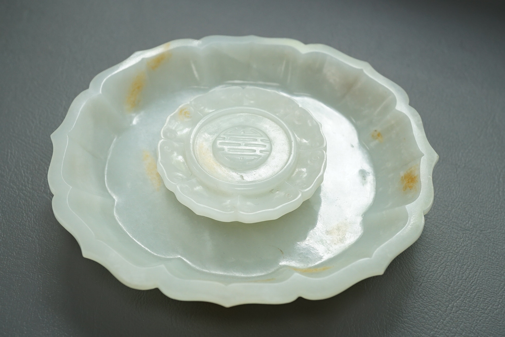 A Chinese white and russet jade petal lobed cup stand